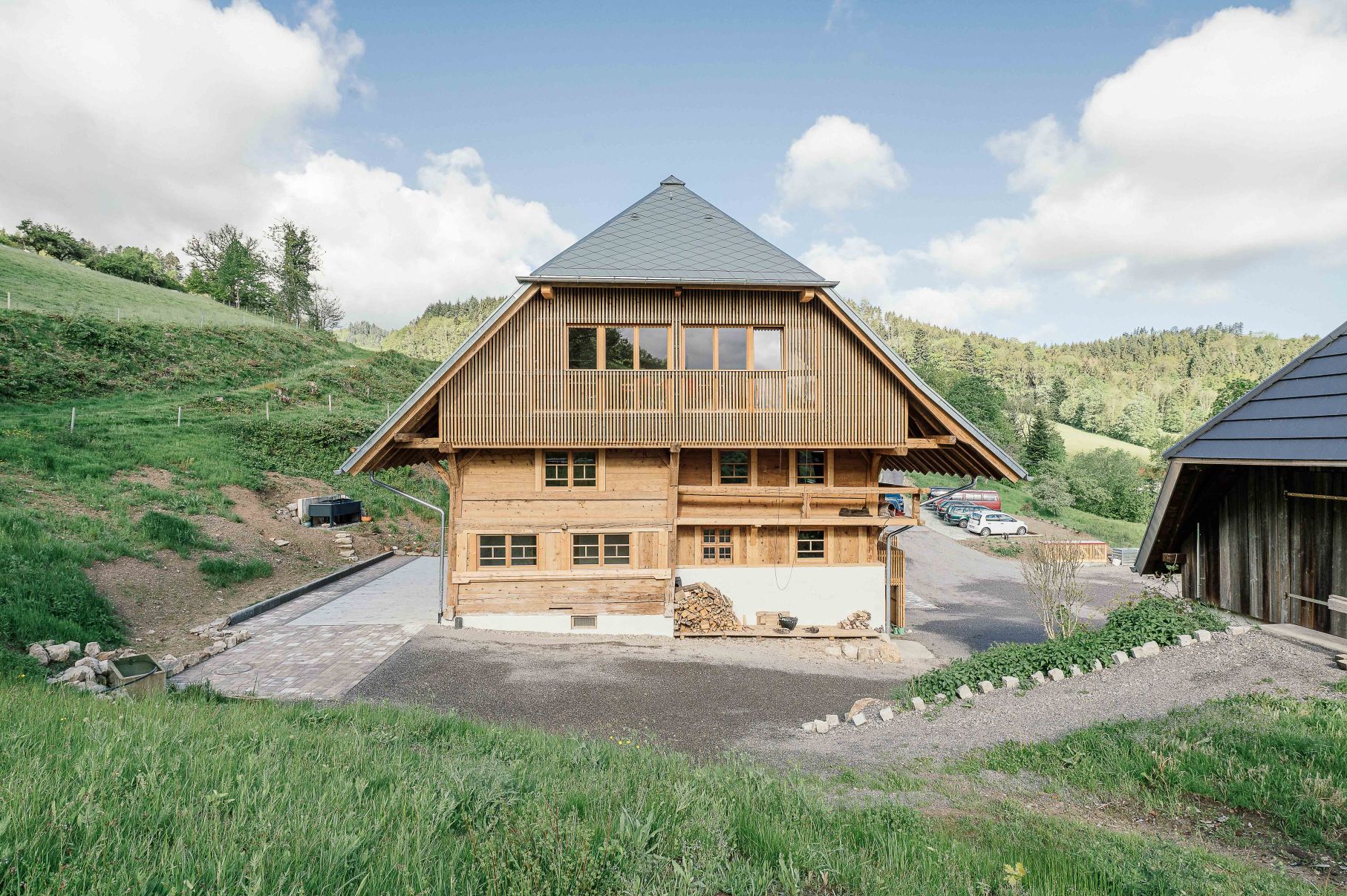 Denkmalgeschützter Schwarzwälder Eindachhof mit instandgesetzter historischer und neuer Fassade in der Bildmitte.