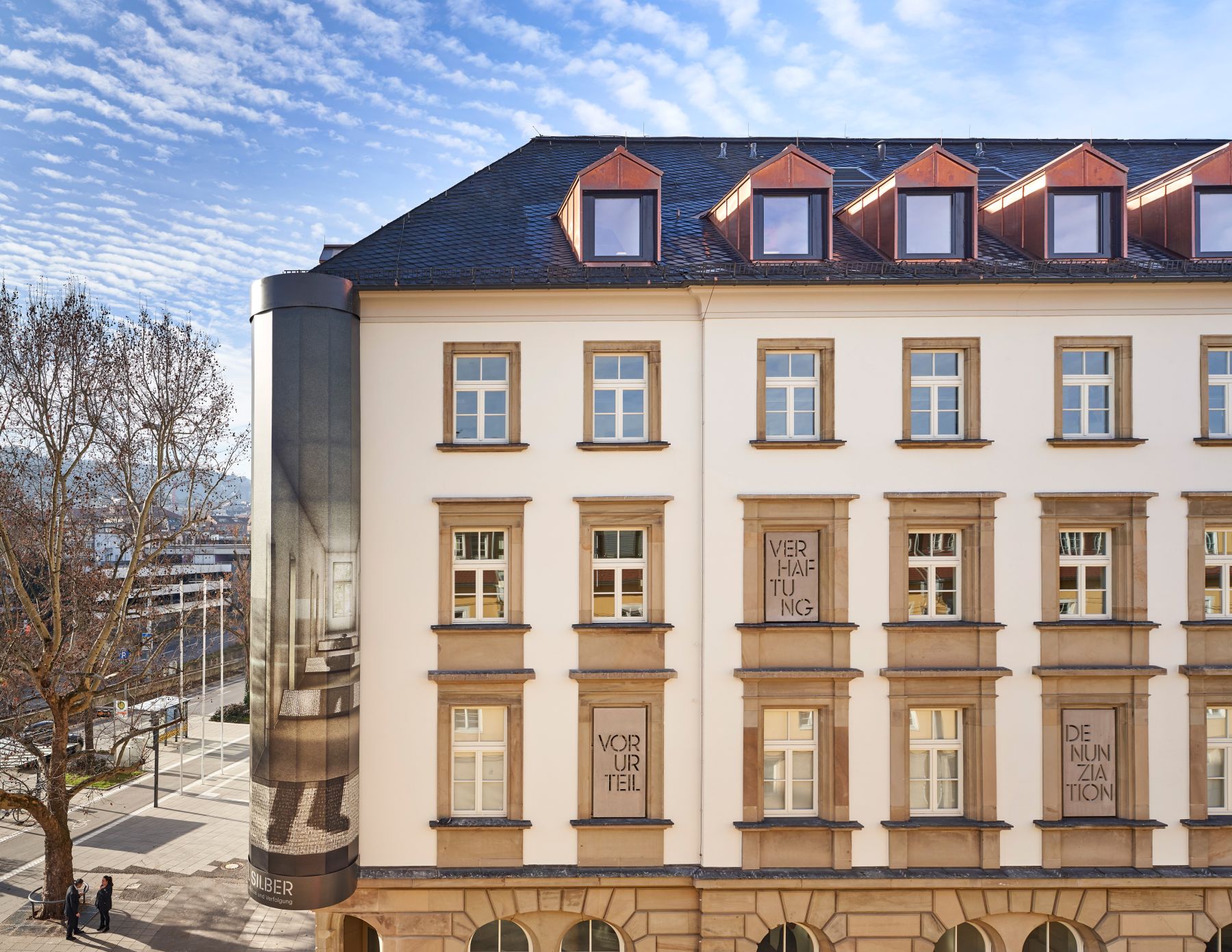 Ansicht der nördlichen Fassade mit beschrifteten Steintafeln in Fensteröffnungen