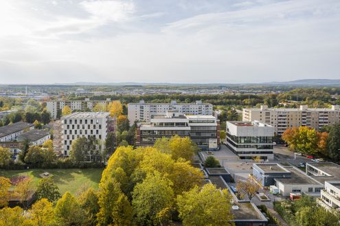 Um- und Weiterbauten in der Großsiedlung "Weingarten-West" sowie Umgestaltungen öffentlicher Räume, Grün- und Freiflächen, zu Teilen sichtbar aus der Vogelperspektive des Bildes.