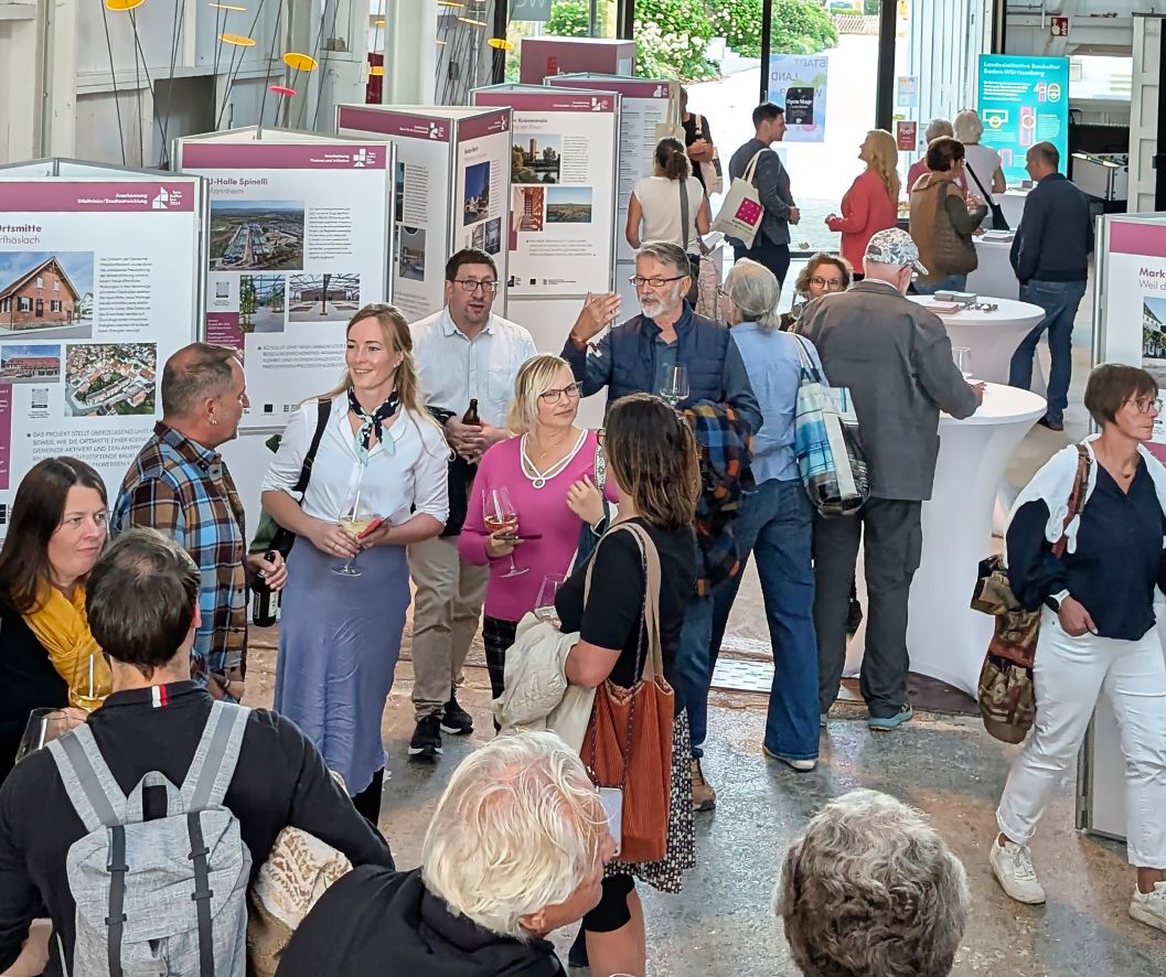 Gäste der Veranstaltung vor der Ausstellung zum Staatspreis Baukultur