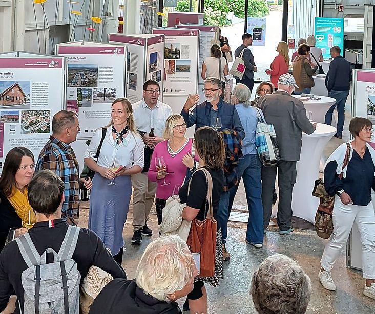 Gäste der Veranstaltung vor der Ausstellung zum Staatspreis Baukultur
