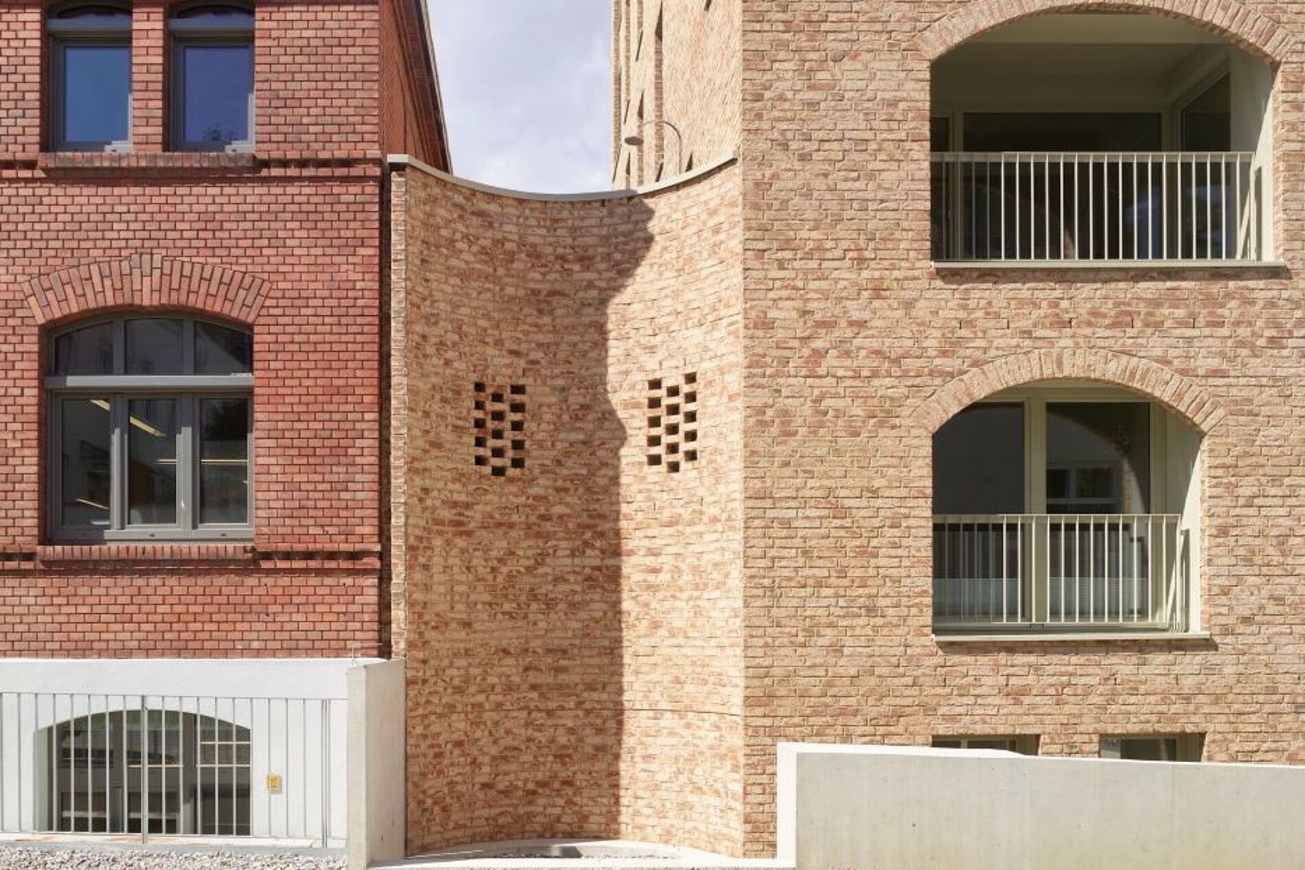 Umbau und Erweiterung des Beznerturms mit beigefarbener Klinkerfassade, Fensteröffnungen in Höhe und Breite mit teilweise Neuintegration von Rund- bzw. Segmentbögen. 